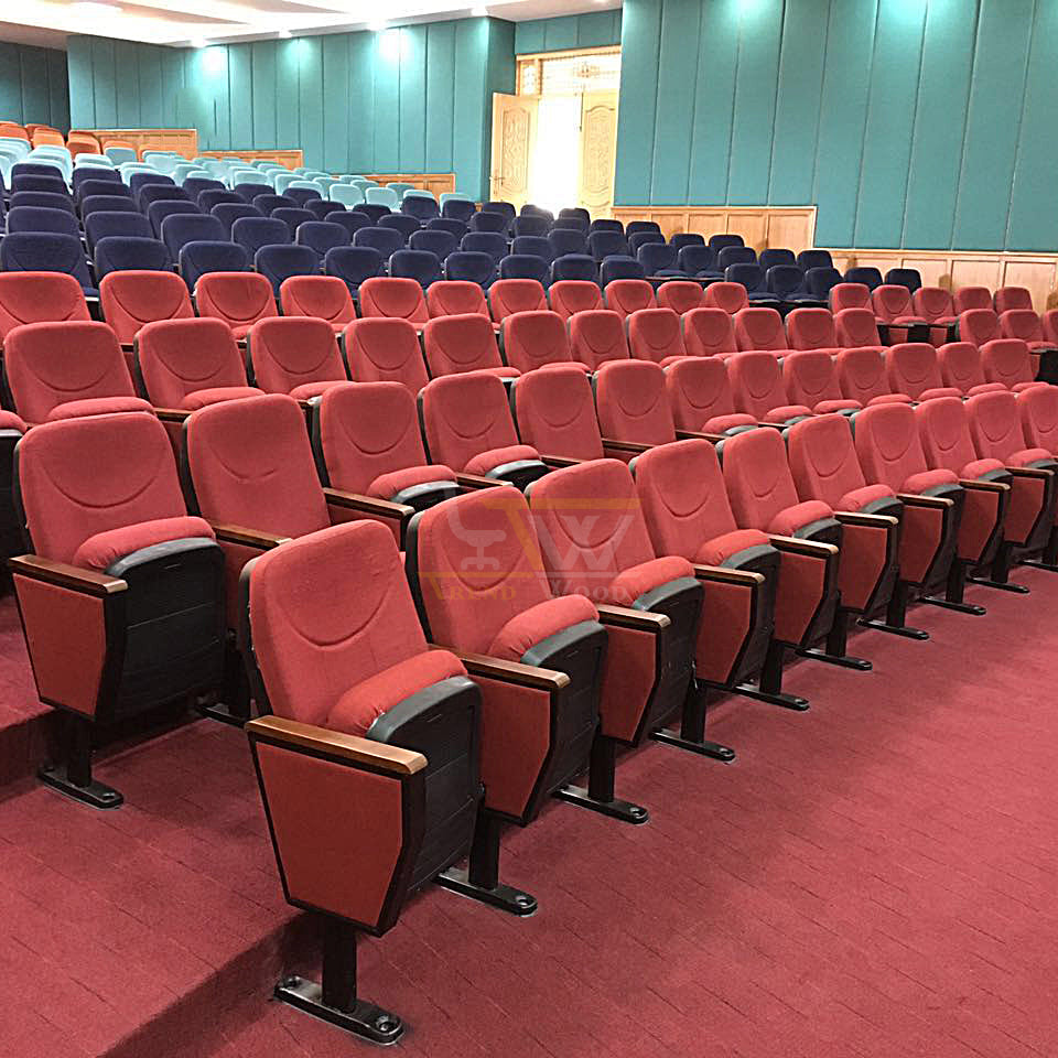 Spacious auditorium interior filled with rows of red cushioned seating